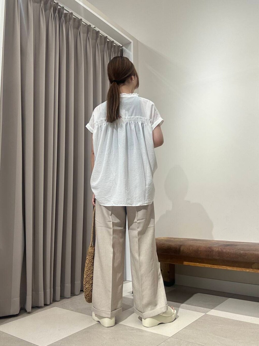 ベージュ系のトートバッグ、ブラック系のタンクトップ、ベージュ系のその他パンツを着用したレディースの夏コーディネートの3枚目の写真