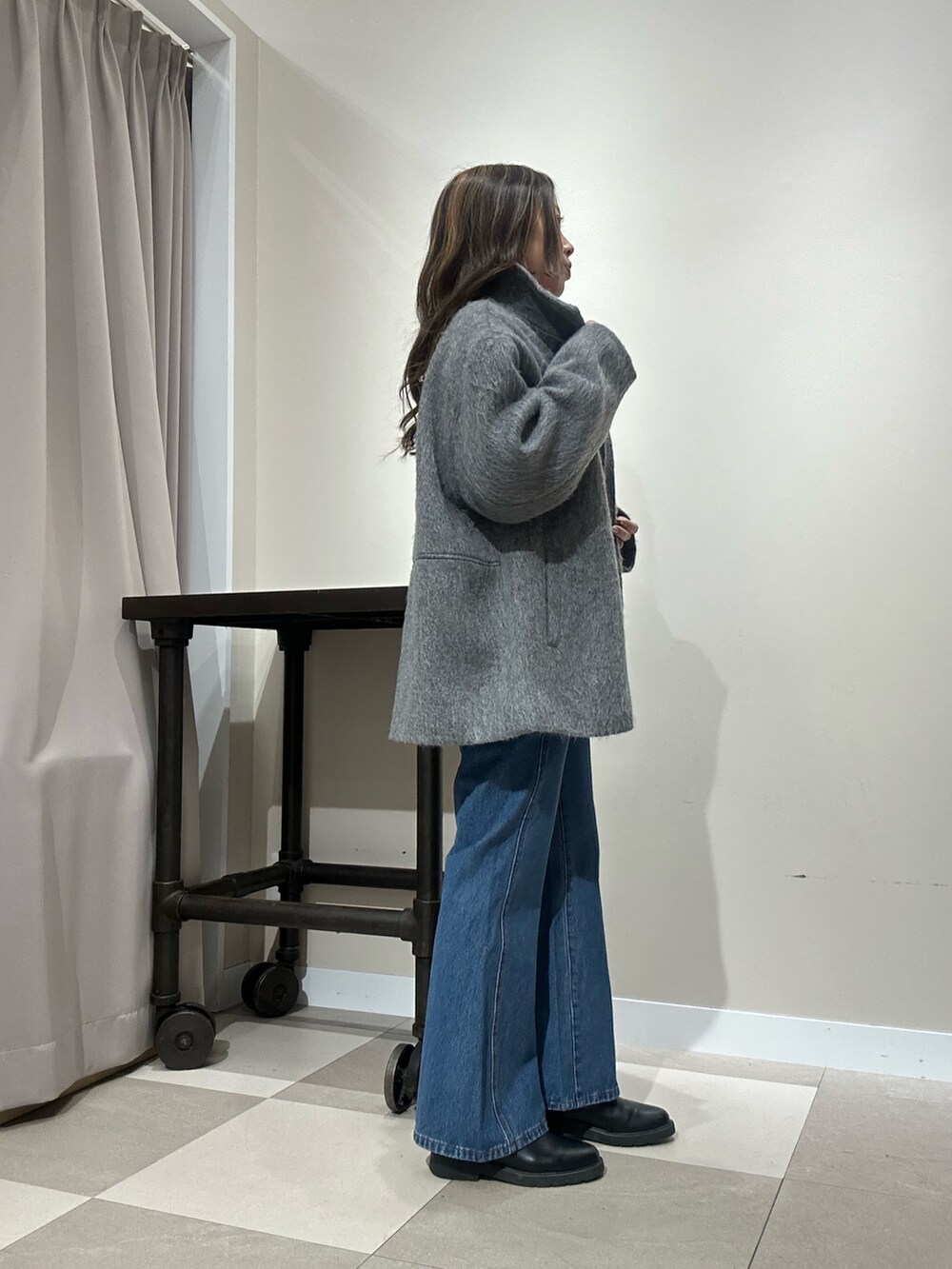 グレー系のその他アウター、レッド系のニット/セーター、ブルー系のデニムパンツを着用したレディースの冬コーディネートの2枚目の写真