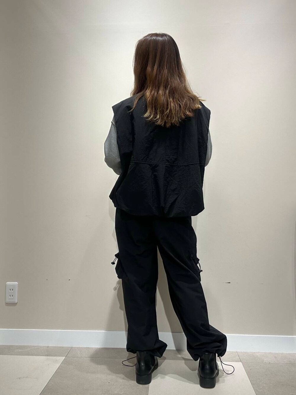 グレー系のニット/セーター、ブラック系のベスト、ブラック系のその他パンツを着用したレディースの秋コーディネートの3枚目の写真