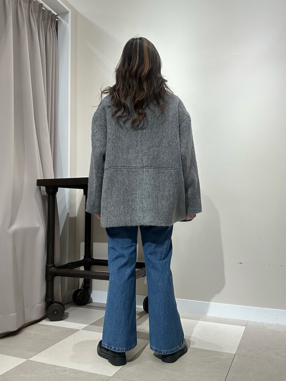 グレー系のその他アウター、レッド系のニット/セーター、ブルー系のデニムパンツを着用したレディースの冬コーディネートの3枚目の写真