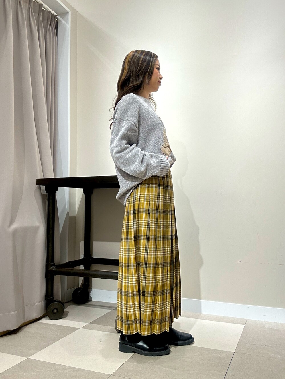 グレー系のニット/セーター、イエロー系のスカートを着用したレディースの冬コーディネートの3枚目の写真