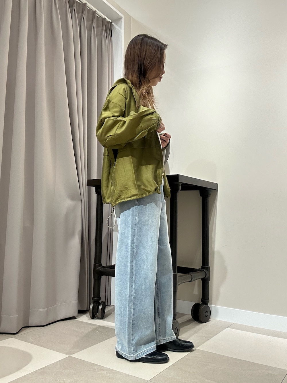 ブルー系のデニムパンツ、ホワイト系のニット/セーター、グリーン系のブルゾンを着用したレディースの秋コーディネートの2枚目の写真