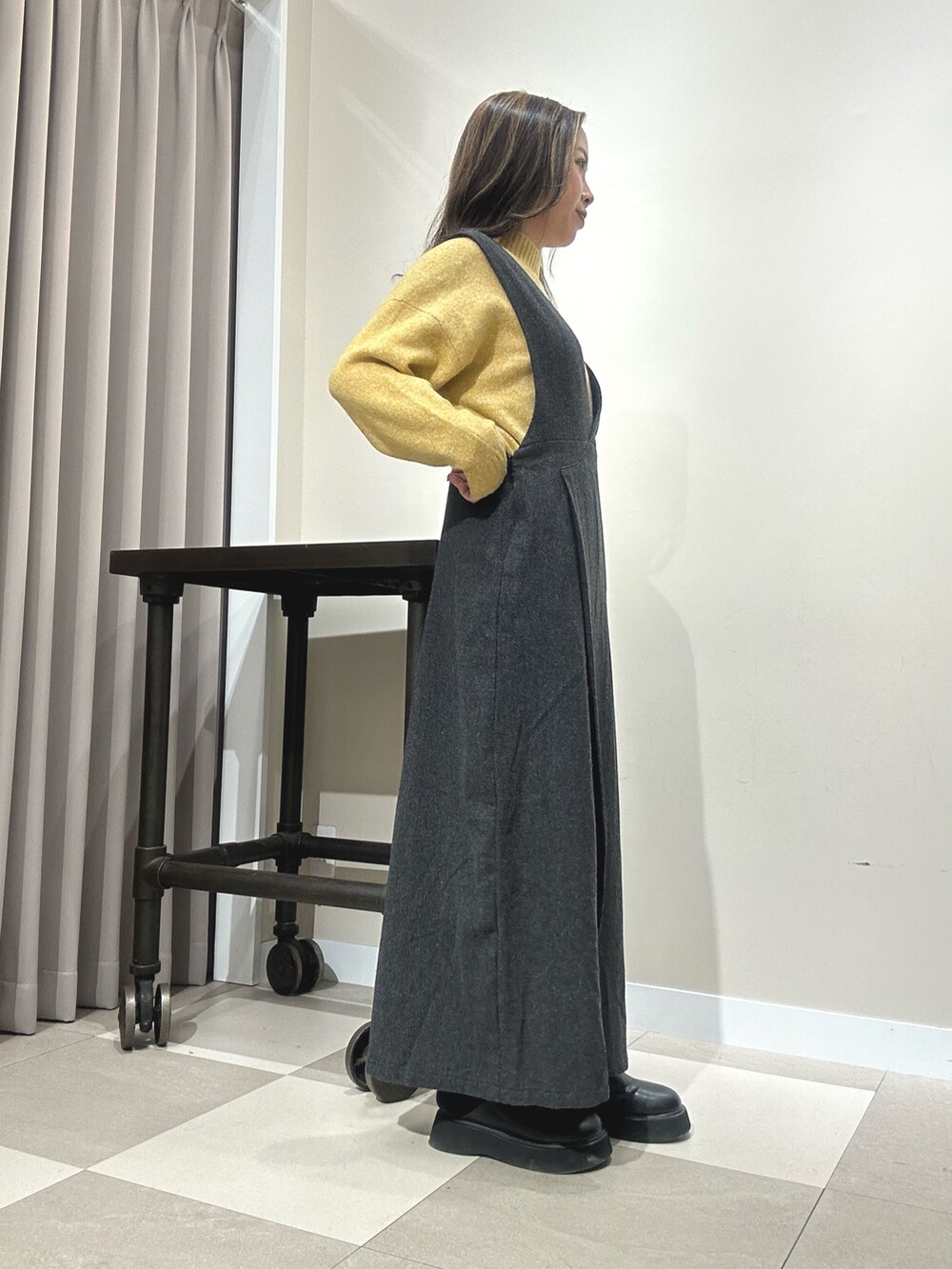 ブラック系のワンピース、イエロー系のニット/セーターを着用したレディースの秋コーディネートの2枚目の写真