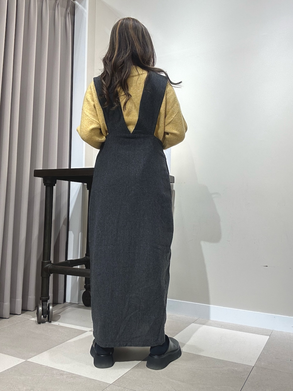 ブラック系のワンピース、イエロー系のニット/セーターを着用したレディースの秋コーディネートの3枚目の写真