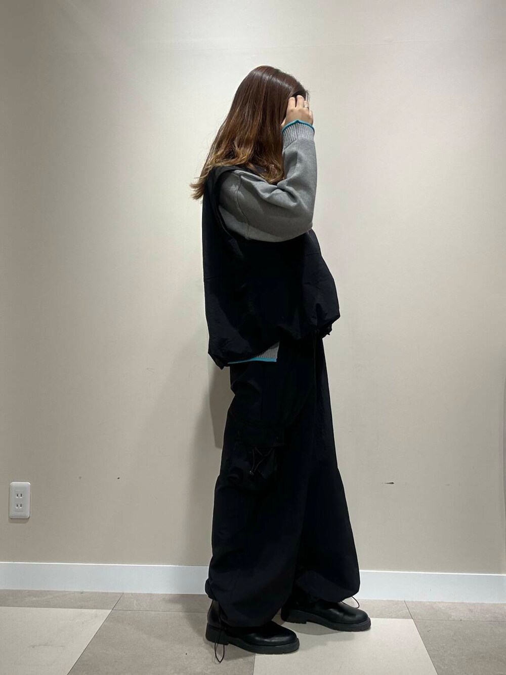 グレー系のニット/セーター、ブラック系のベスト、ブラック系のその他パンツを着用したレディースの秋コーディネートの2枚目の写真