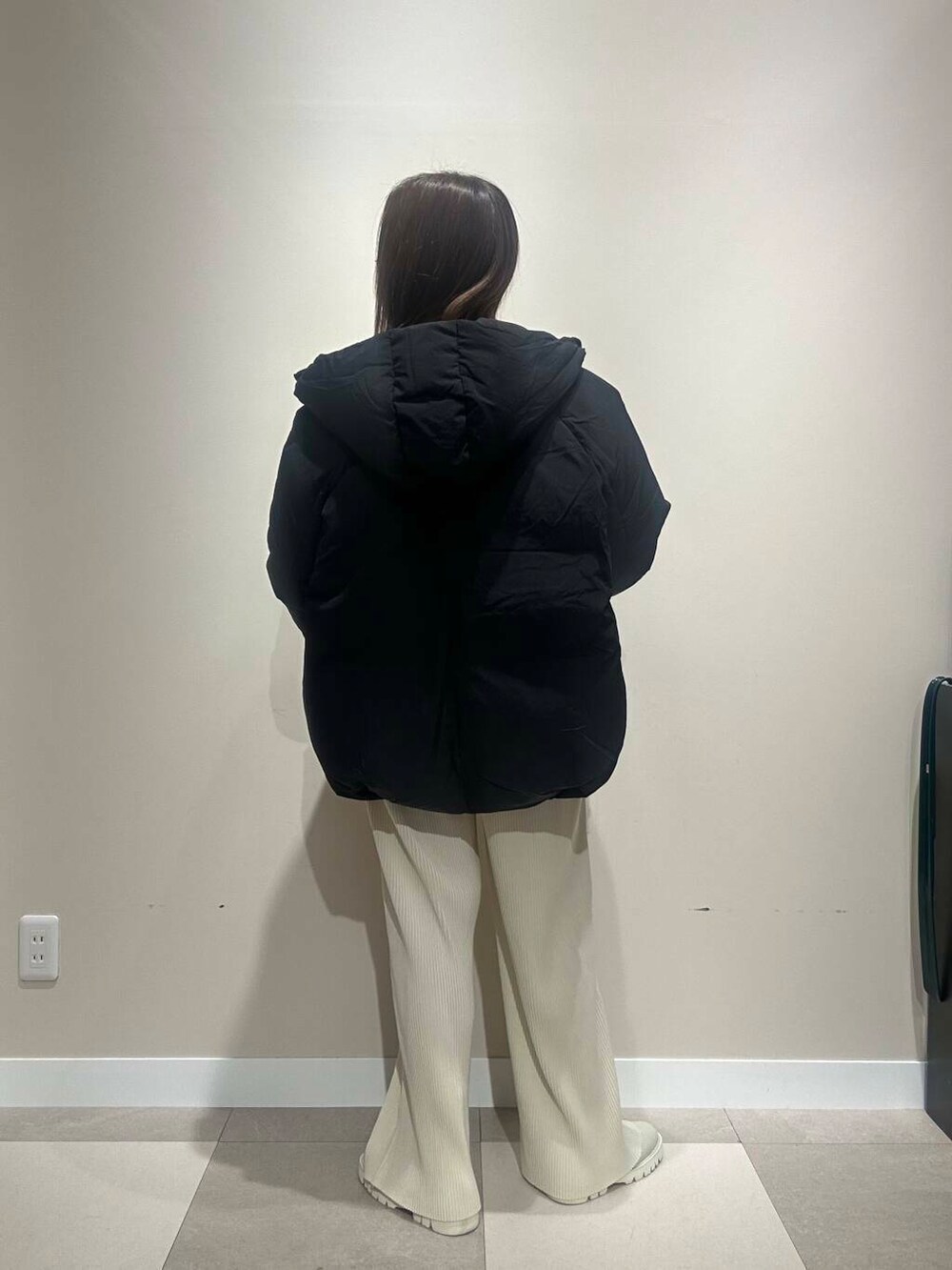 ホワイト系のその他パンツ、ブラック系のダウンジャケット/コート、グレー系のニット/セーターを着用したレディースの冬コーディネートの3枚目の写真