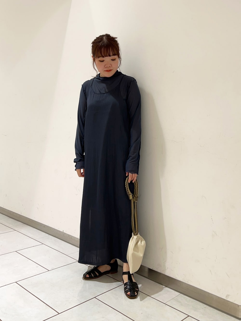 ブルー系のワンピース、ベージュ系のショルダーバッグを着用したレディースの春コーディネートの2枚目の写真