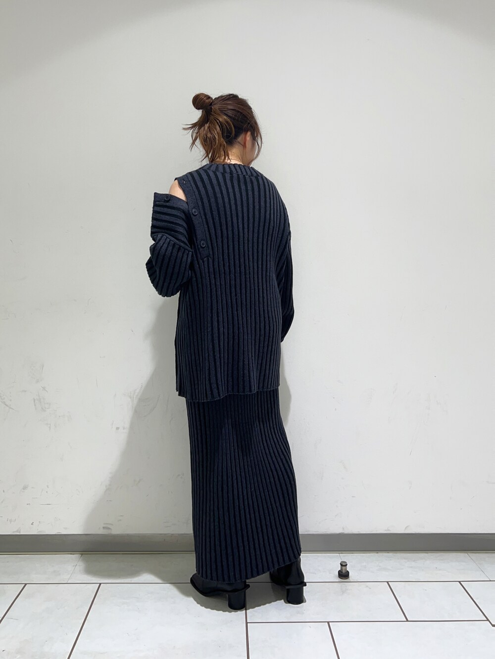 ブルー系のニット/セーター、ブルー系のスカート、ブラック系のブーツを着用したレディースの冬コーディネートの2枚目の写真