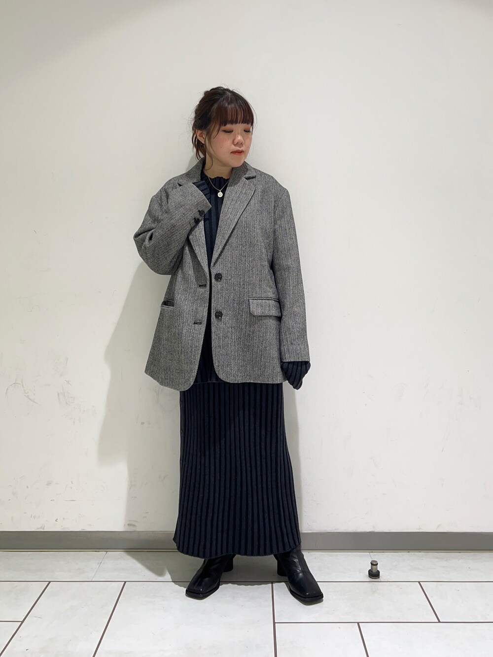 ブルー系のニット/セーター、ブルー系のスカート、ブラック系のブーツを着用したレディースの冬コーディネートの3枚目の写真