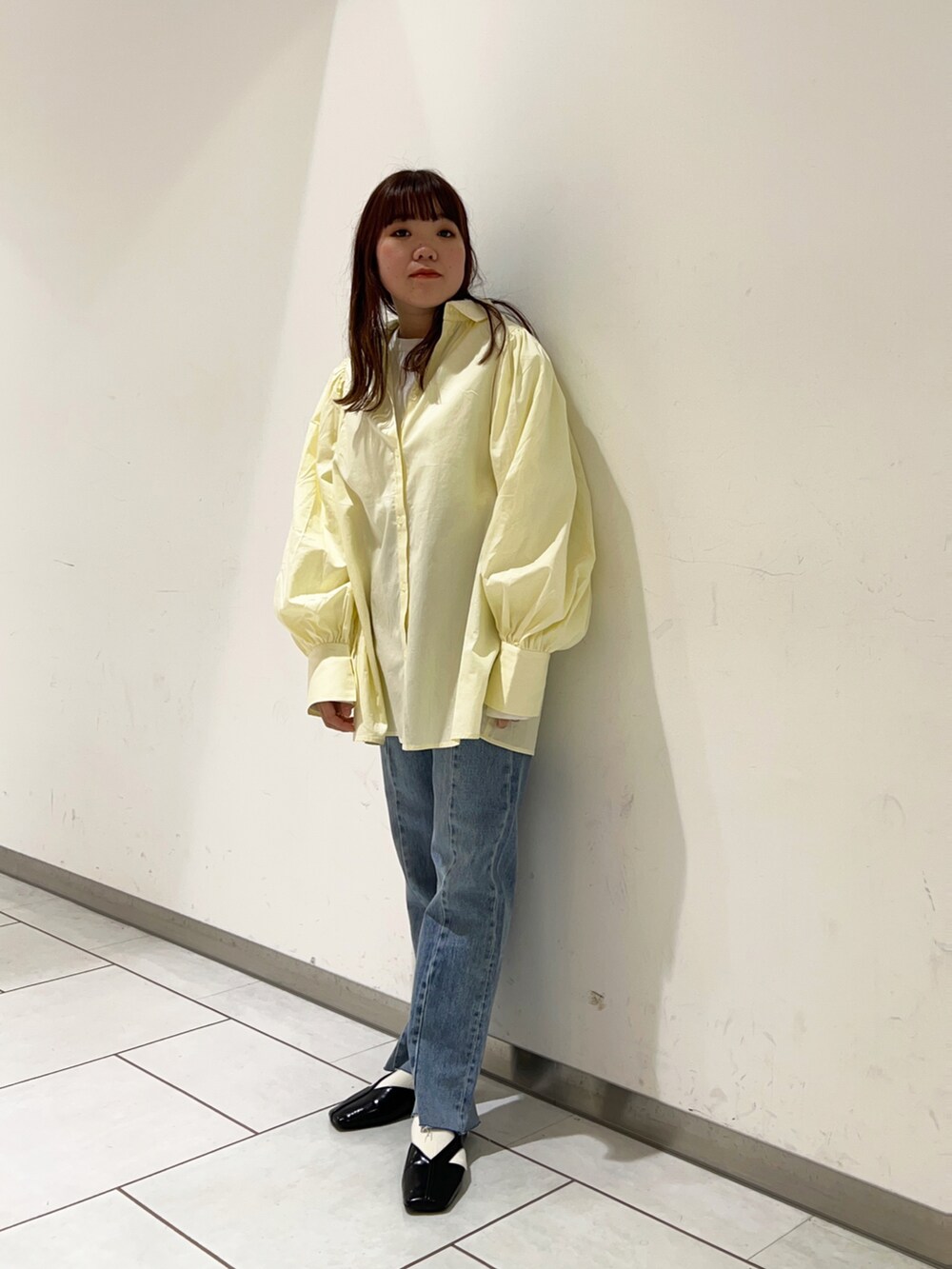 ホワイト系のシャツ/ブラウス、ブルー系のデニムパンツ、ブラック系のサンダルを着用したレディースの春コーディネートの2枚目の写真