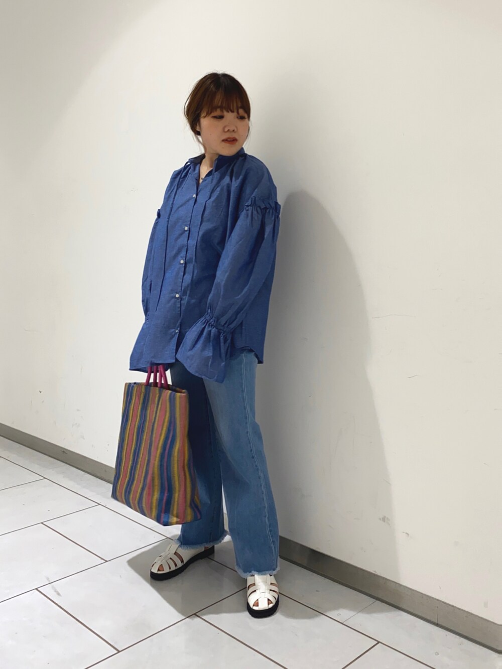 ブルー系のシャツ/ブラウス、ホワイト系のサンダル、ブルー系のデニムパンツを着用したレディースの春コーディネートの2枚目の写真