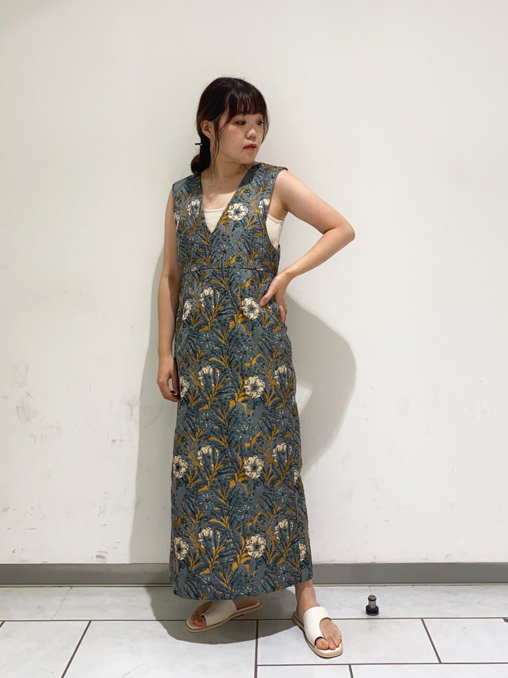 イエロー系のワンピース、ホワイト系のサンダルを着用したレディースの夏コーディネートの2枚目の写真