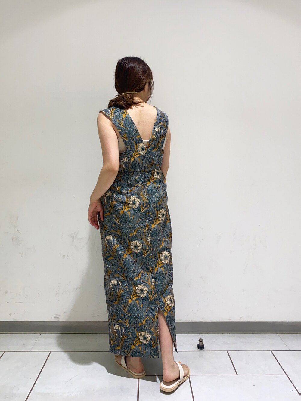 イエロー系のワンピース、ホワイト系のサンダルを着用したレディースの夏コーディネートの3枚目の写真