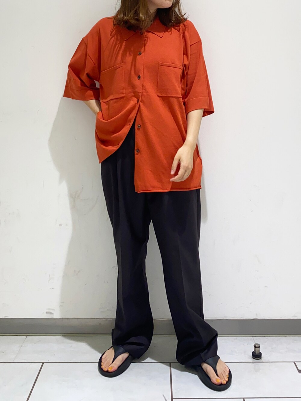 オレンジ系のニット/セーター、ブラウン系のその他パンツを着用したレディースの夏コーディネートの3枚目の写真