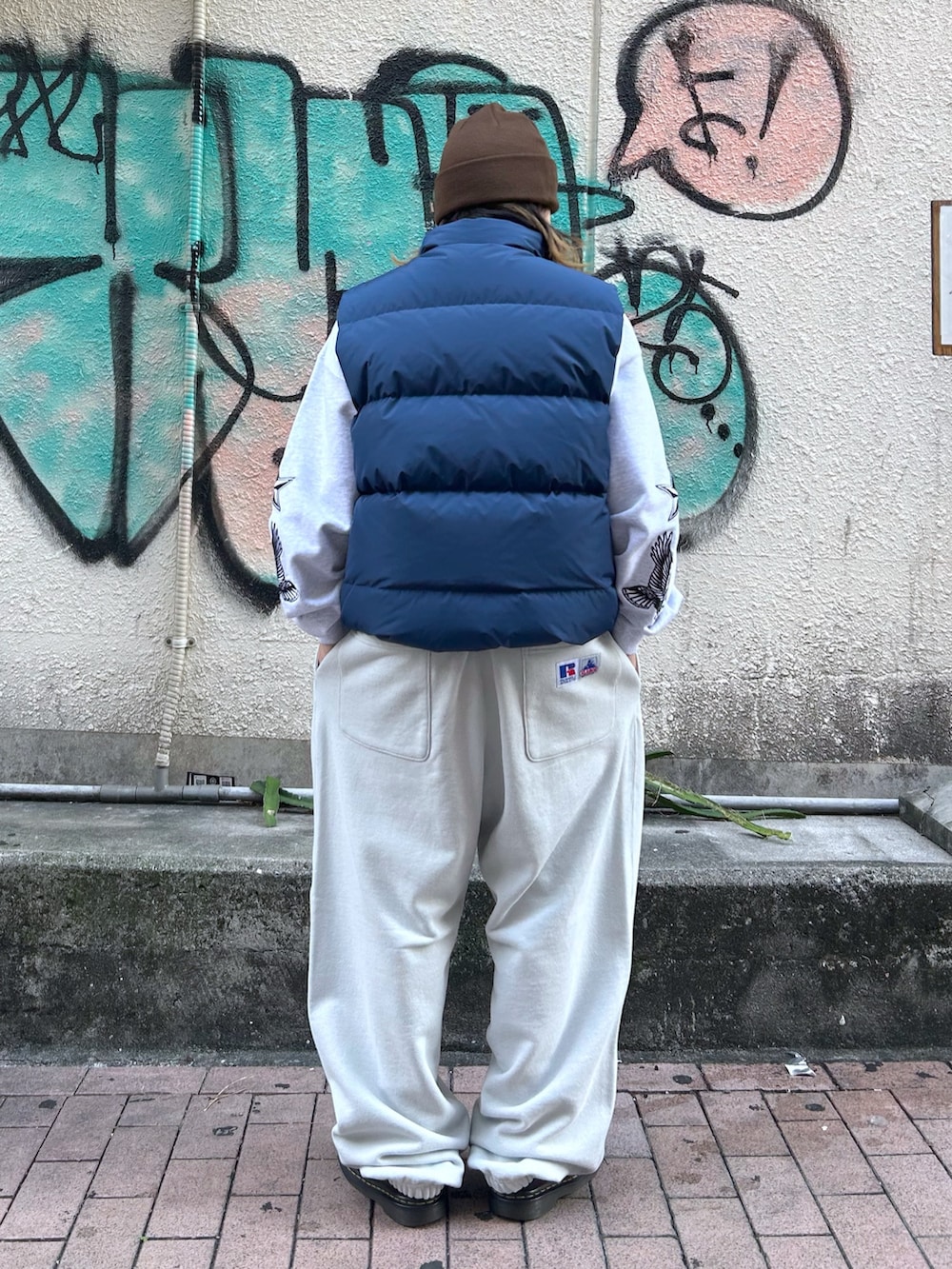 ブルー系のダウンベスト、グレー系のスウェット、グレー系のスウェットパンツを着用したレディースの秋コーディネートの2枚目の写真