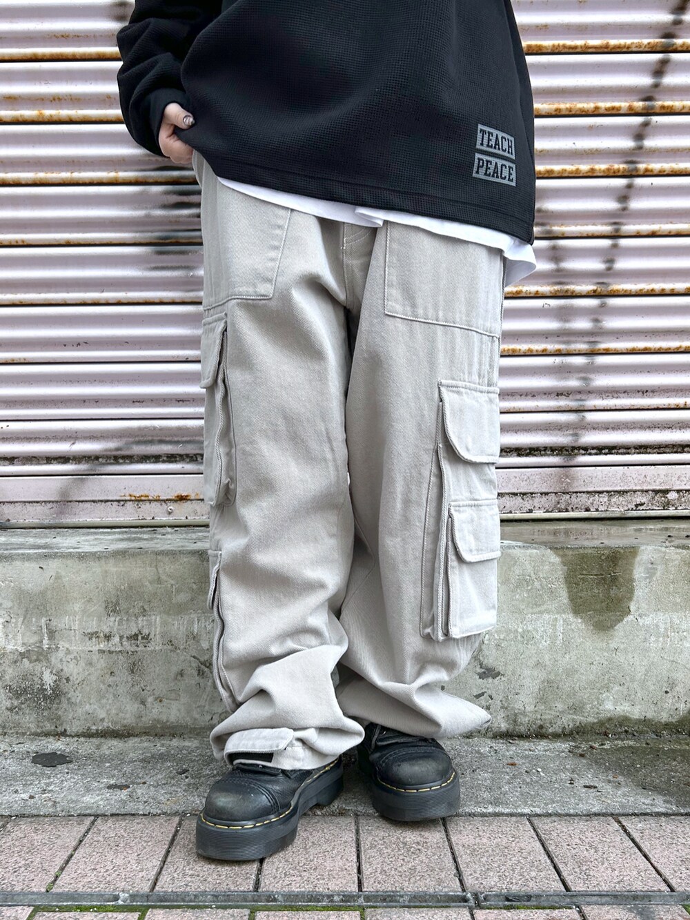 ブラック系のTシャツ/カットソー、グレー系のカーゴパンツ、パープル系のキャップを着用したレディースの春コーディネートの5枚目の写真