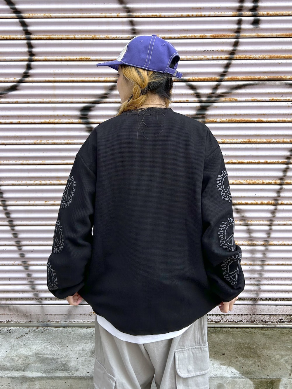 ブラック系のTシャツ/カットソー、グレー系のカーゴパンツ、パープル系のキャップを着用したレディースの春コーディネートの4枚目の写真