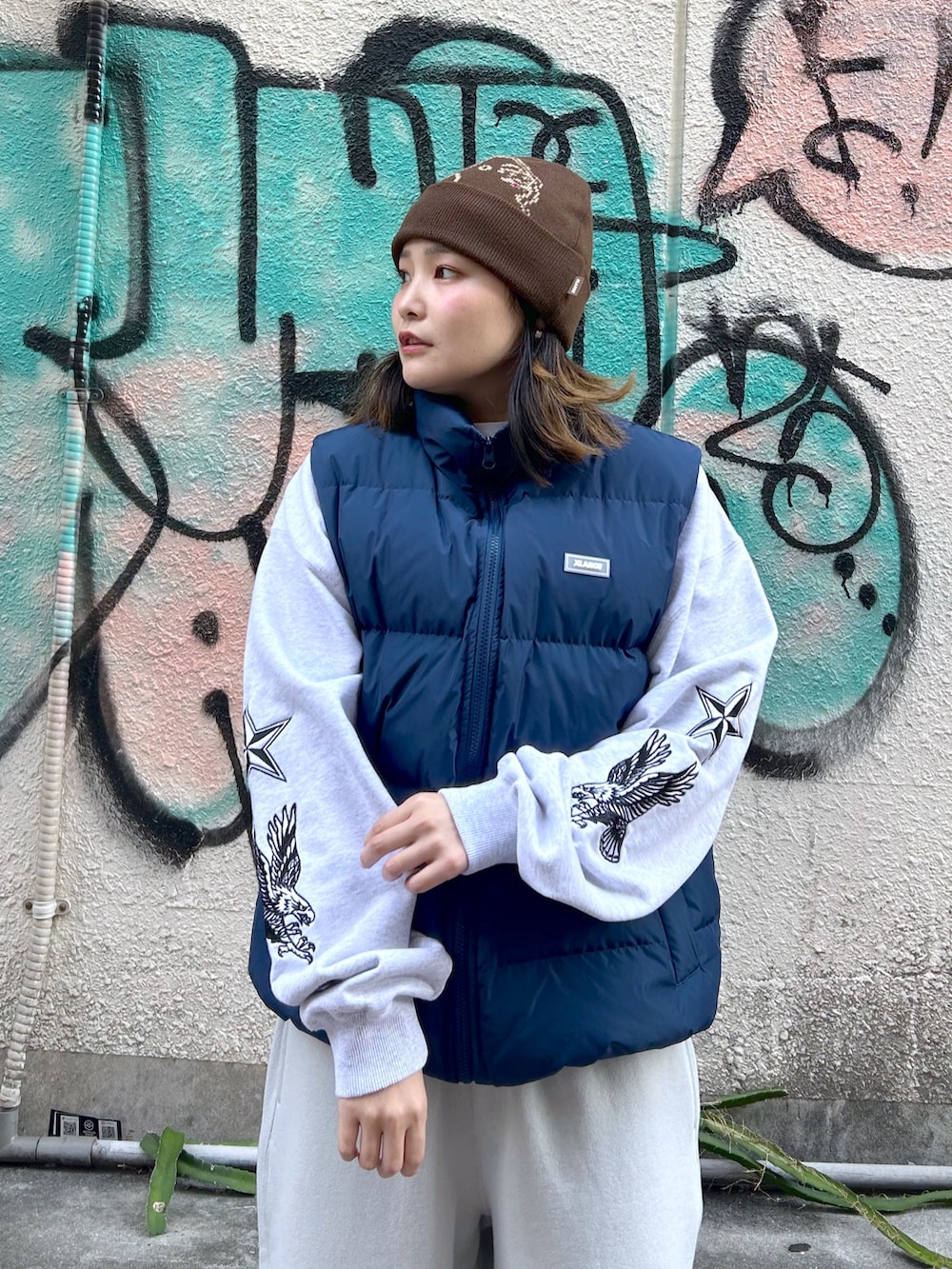 ブルー系のダウンベスト、グレー系のスウェット、グレー系のスウェットパンツを着用したレディースの秋コーディネートの3枚目の写真