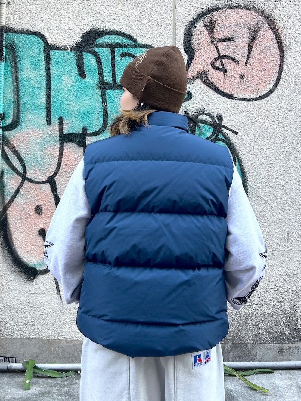 ブルー系のダウンベスト、グレー系のスウェット、グレー系のスウェットパンツを着用したレディースの秋コーディネートの4枚目の写真