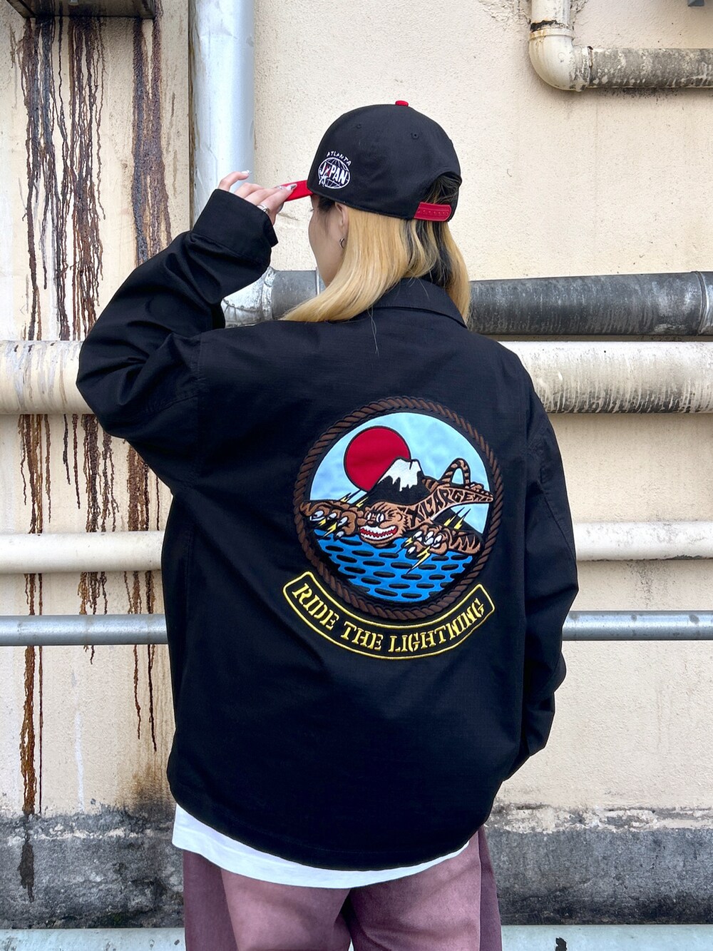 ホワイト系のTシャツ/カットソー、ブラック系のシャツ/ブラウス、グリーン系のデニムパンツを着用したレディースの春コーディネートの4枚目の写真