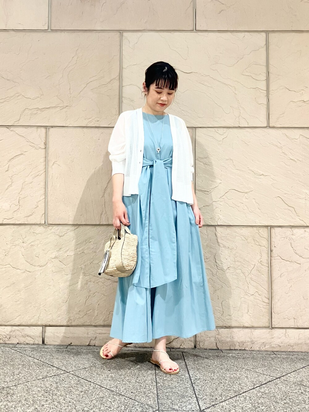 ブルー系のワンピース、ゴールド系のかごバッグ、ホワイト系のカーディガン/ボレロを着用したレディースの夏コーディネートの4枚目の写真