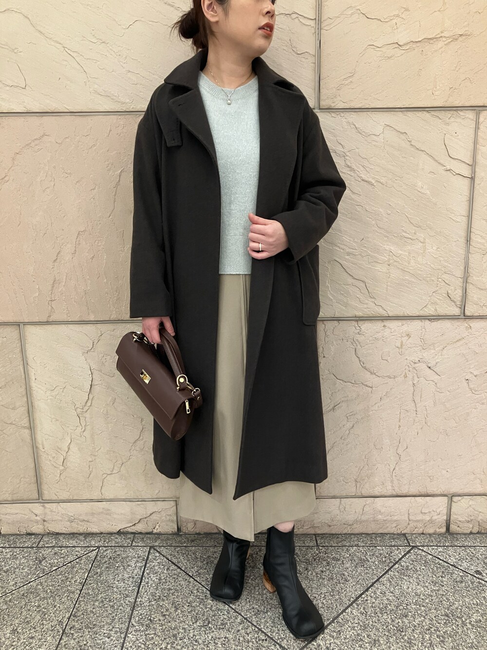 グリーン系のニット/セーター、ブラウン系のその他アウター、ベージュ系のスカートを着用したレディースの冬コーディネートの4枚目の写真