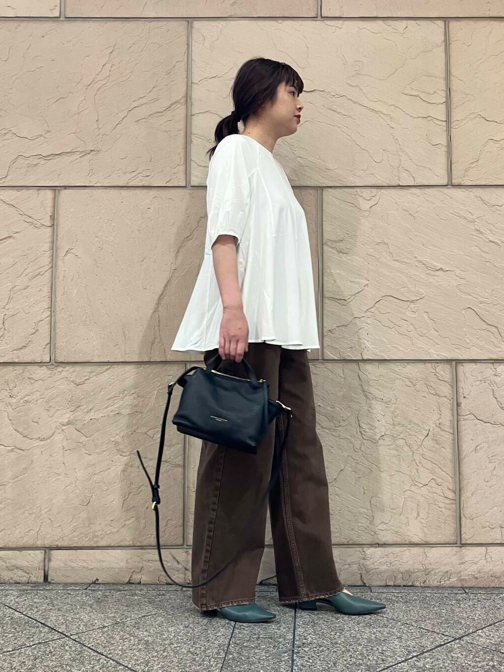 ホワイト系のTシャツ/カットソー、ブラック系のハンドバッグ、グリーン系のパンプスを着用したレディースの夏コーディネートの2枚目の写真