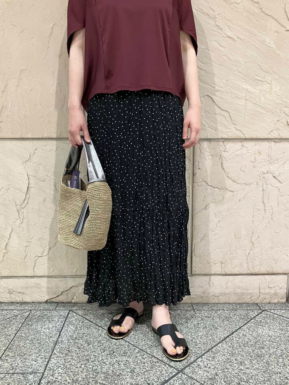 ブラウン系のかごバッグ、レッド系のTシャツ/カットソー、ブラック系のスカートを着用したレディースの夏コーディネートの5枚目の写真