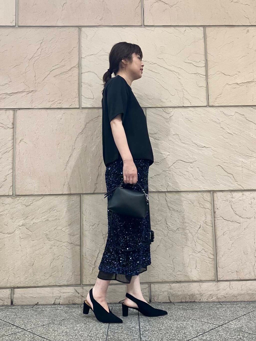 ブラック系のTシャツ/カットソーを着用したレディースの夏コーディネートの2枚目の写真