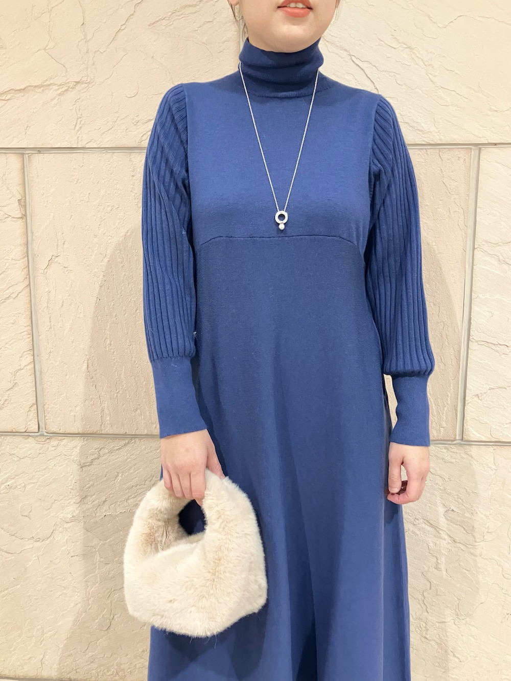 ブルー系のワンピース、ブラック系のブーツ、シルバー系のネックレスを着用したレディースの秋コーディネートの4枚目の写真