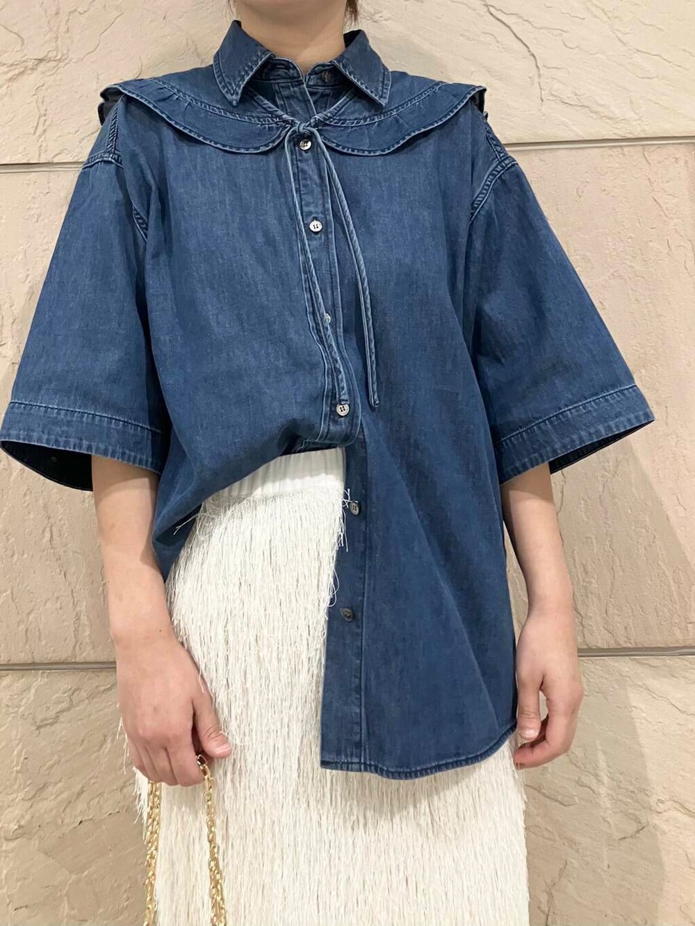 ブルー系のシャツ/ブラウス、ブラウン系のハンドバッグ、ホワイト系のスカートを着用したレディースの夏コーディネートの3枚目の写真