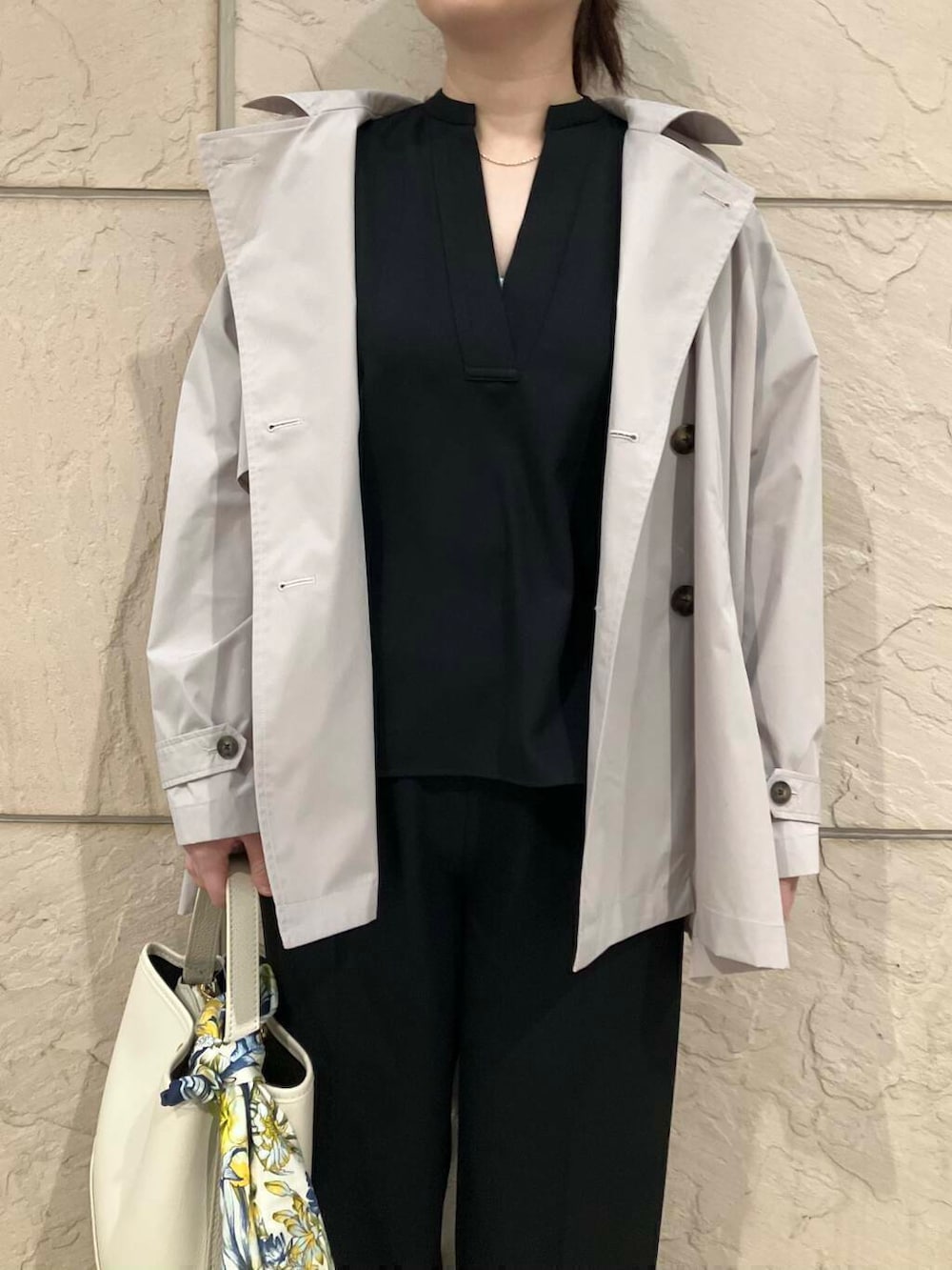 ブラック系のパンプス、ベージュ系のトレンチコート、ホワイト系のハンドバッグを着用したレディースの春コーディネートの5枚目の写真