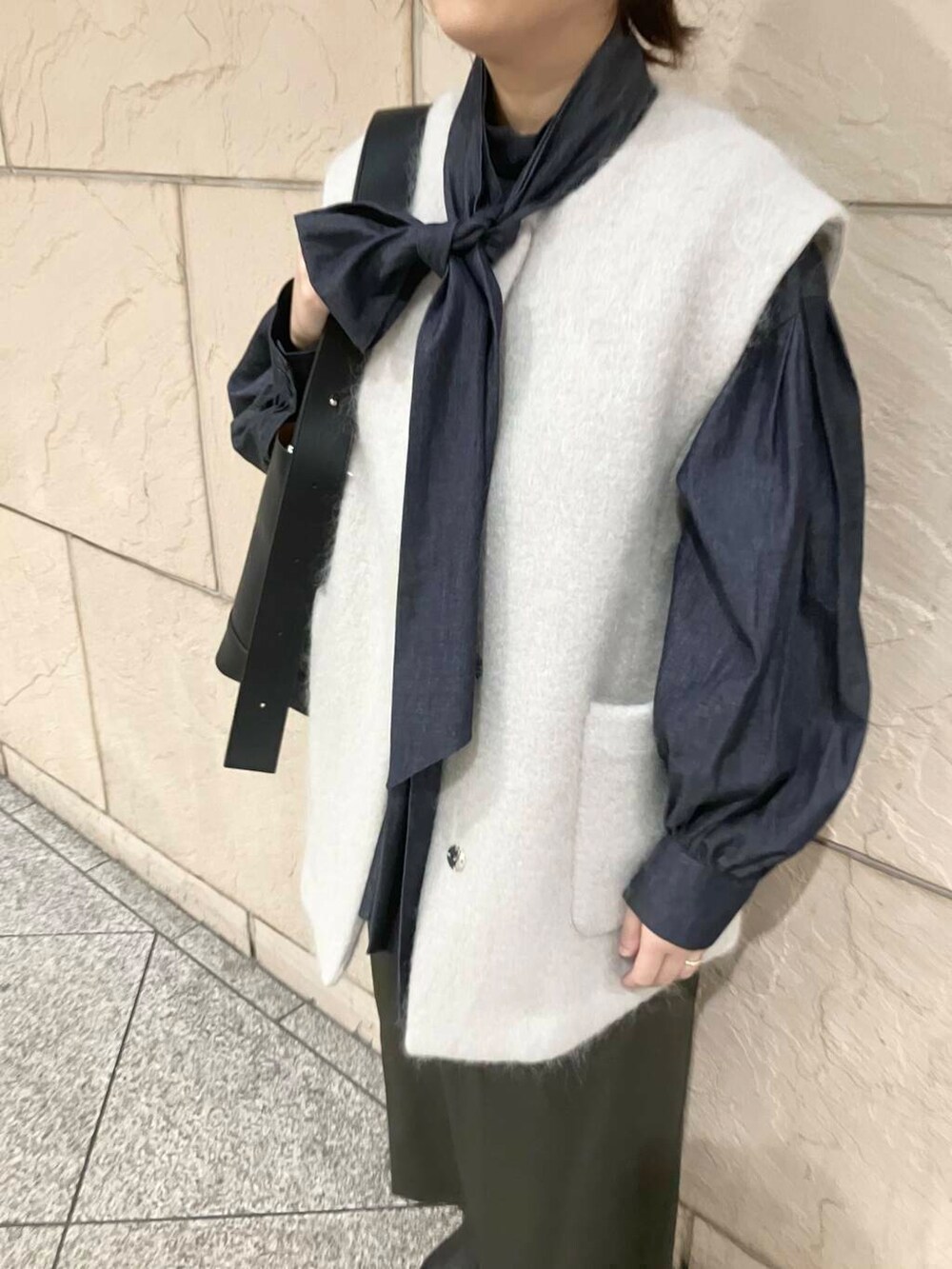 ブラック系のブーツ、グリーン系のスカート、ベージュ系のその他アウターを着用したレディースの秋コーディネートの4枚目の写真