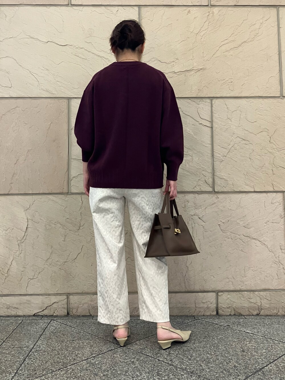 ホワイト系のその他パンツ、レッド系のニット/セーター、ブラウン系のトートバッグを着用したレディースの秋コーディネートの3枚目の写真