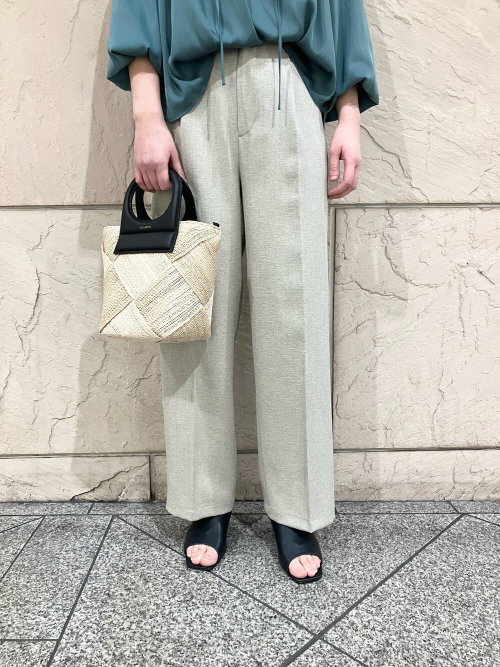グリーン系のシャツ/ブラウス、ベージュ系のパンツ、ベージュ系のハンドバッグを着用したレディースの春コーディネートの4枚目の写真