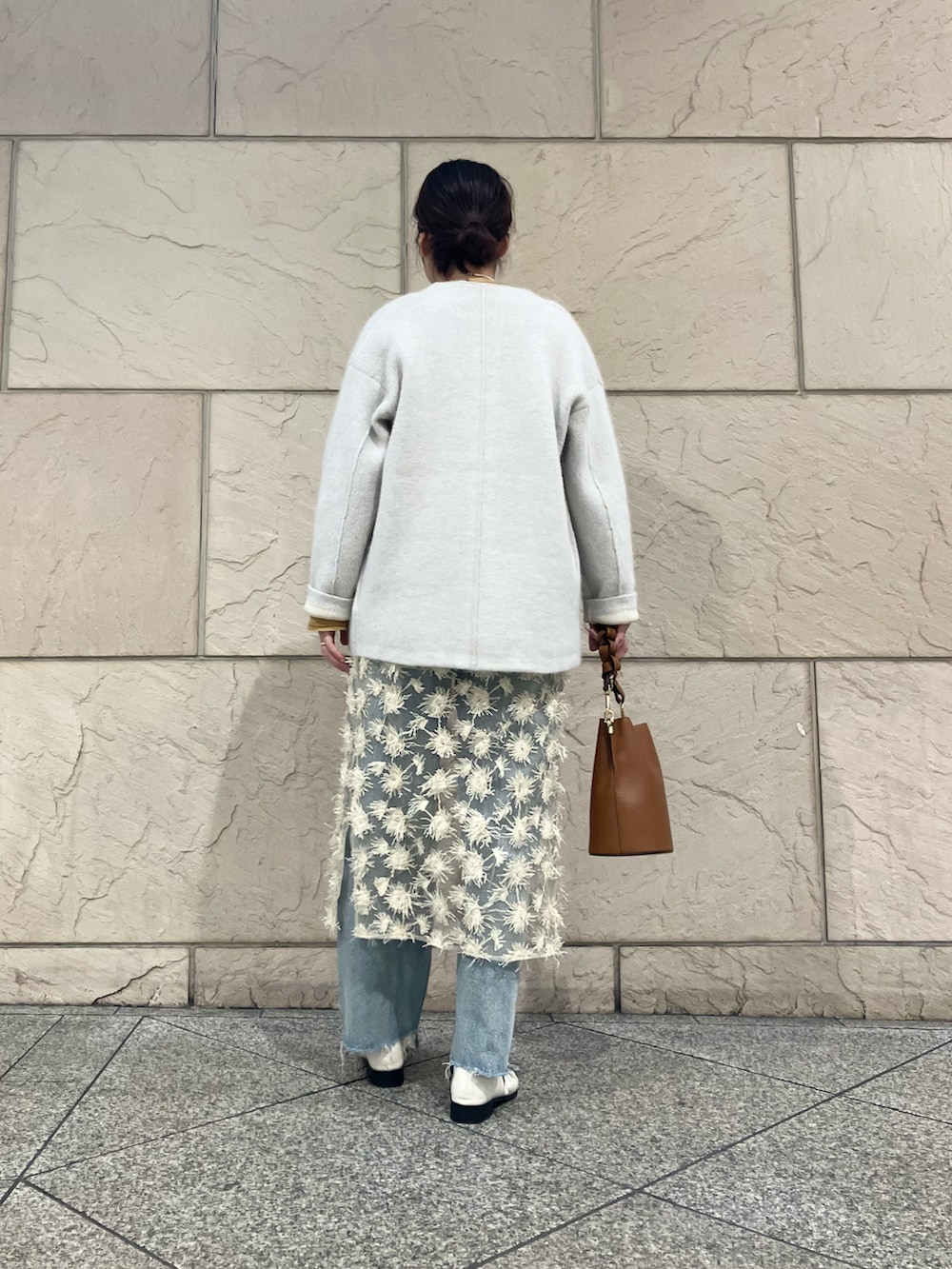 イエロー系のシャツ/ブラウス、グレー系のカーディガン/ボレロ、ベージュ系のスカートを着用したレディースの秋コーディネートの2枚目の写真