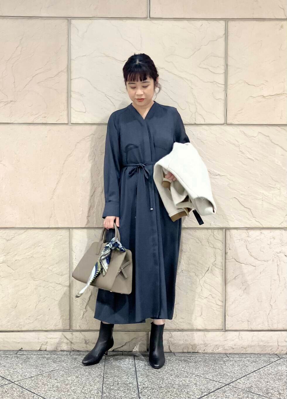 グレー系のワンピース、グレー系のカーディガン/ボレロ、ブラック系のブーツを着用したレディースの秋コーディネートの4枚目の写真