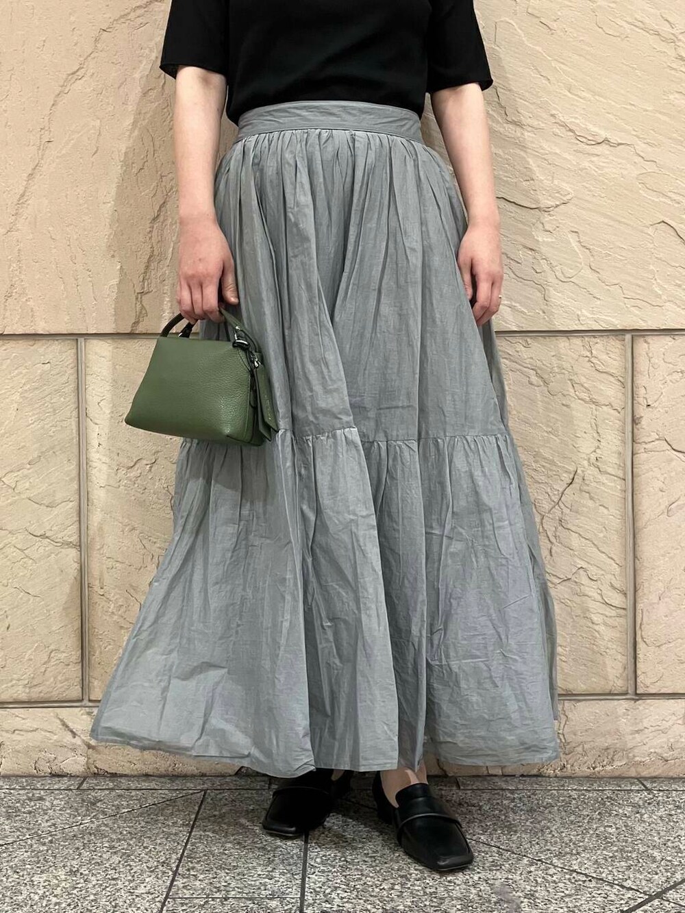 ブラック系のTシャツ/カットソー、グレー系のスカート、グリーン系のショルダーバッグを着用したレディースの夏コーディネートの6枚目の写真