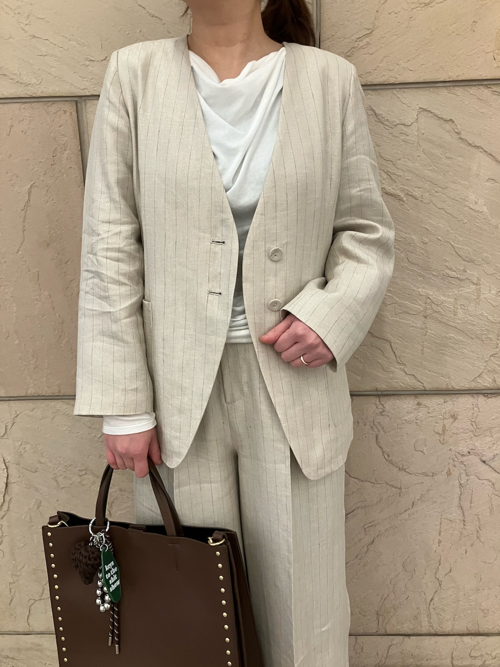 ホワイト系のTシャツ/カットソー、ベージュ系のノーカラージャケット、ベージュ系のその他パンツを着用したレディースの春コーディネートの4枚目の写真