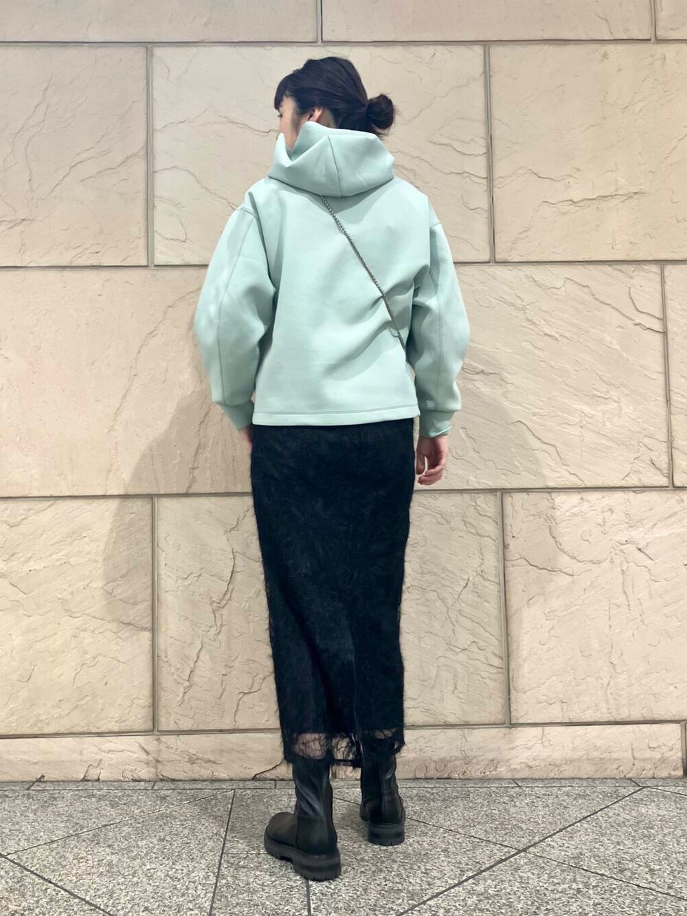 ブラック系のブーツ、シルバー系のショルダーバッグ、ブラック系のスカートを着用したレディースの冬コーディネートの3枚目の写真