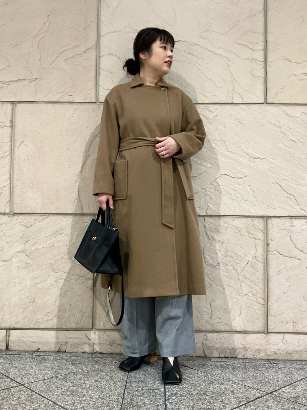 レッド系のニット/セーター、ベージュ系のその他アウター、グレー系のパンツを着用したレディースの秋コーディネートの4枚目の写真