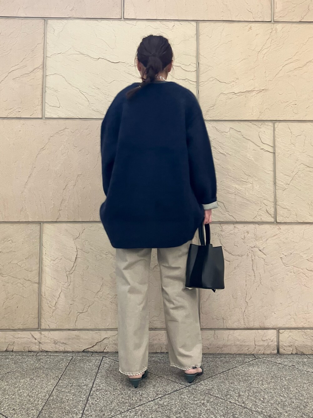 グレー系のTシャツ/カットソー、ベージュ系のデニムパンツ、ブラック系のハンドバッグを着用したレディースの秋コーディネートの3枚目の写真