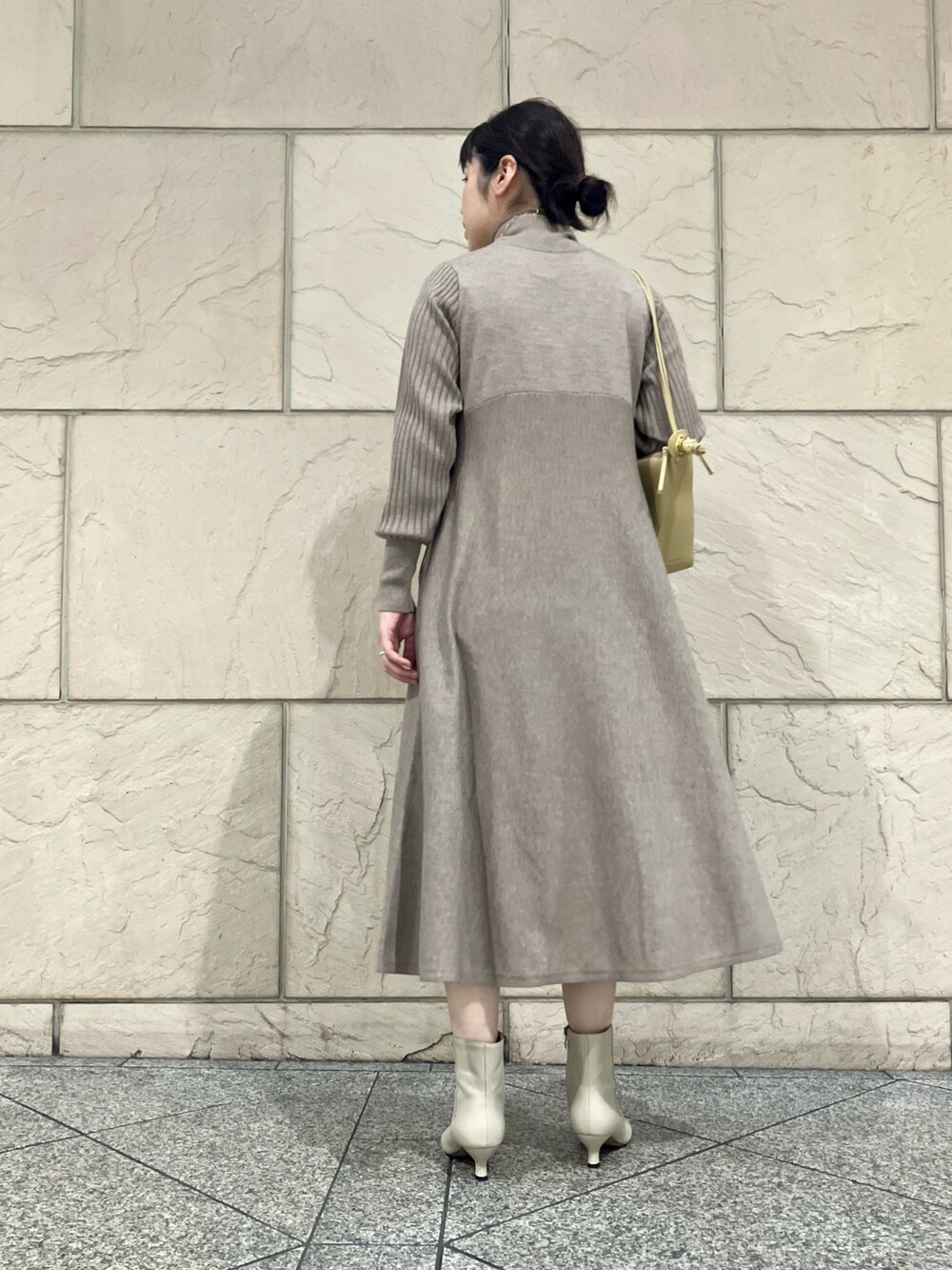 ベージュ系のワンピース、ホワイト系のブーツ、ゴールド系のネックレスを着用したレディースの秋コーディネートの2枚目の写真