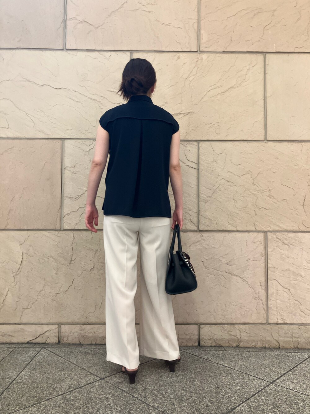 ブルー系のシャツ/ブラウス、ブラック系のトートバッグ、ホワイト系のパンツを着用したレディースの春コーディネートの2枚目の写真