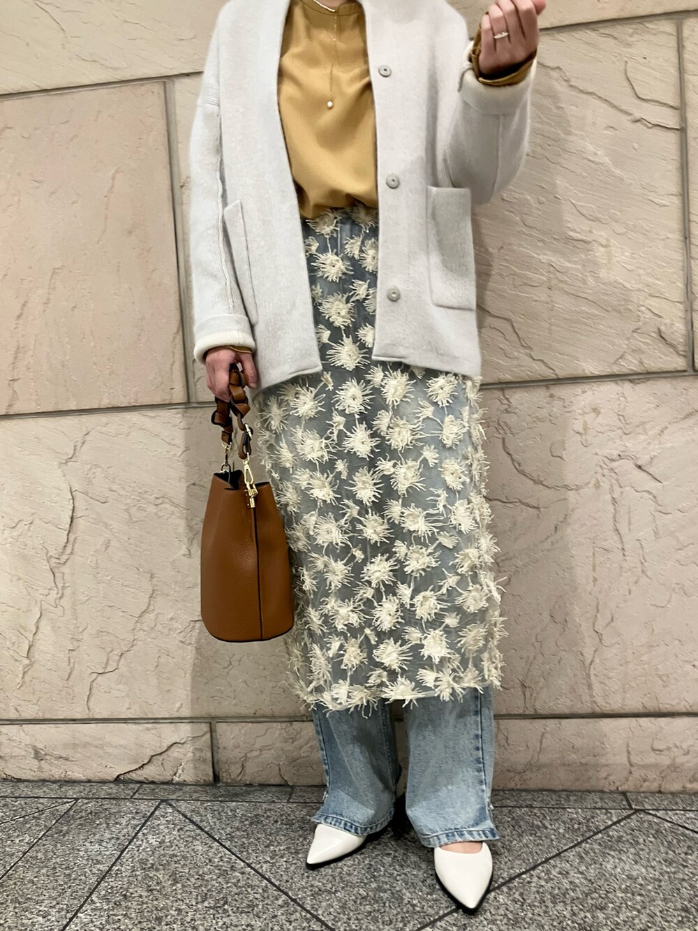 イエロー系のシャツ/ブラウス、グレー系のカーディガン/ボレロ、ベージュ系のスカートを着用したレディースの秋コーディネートの5枚目の写真