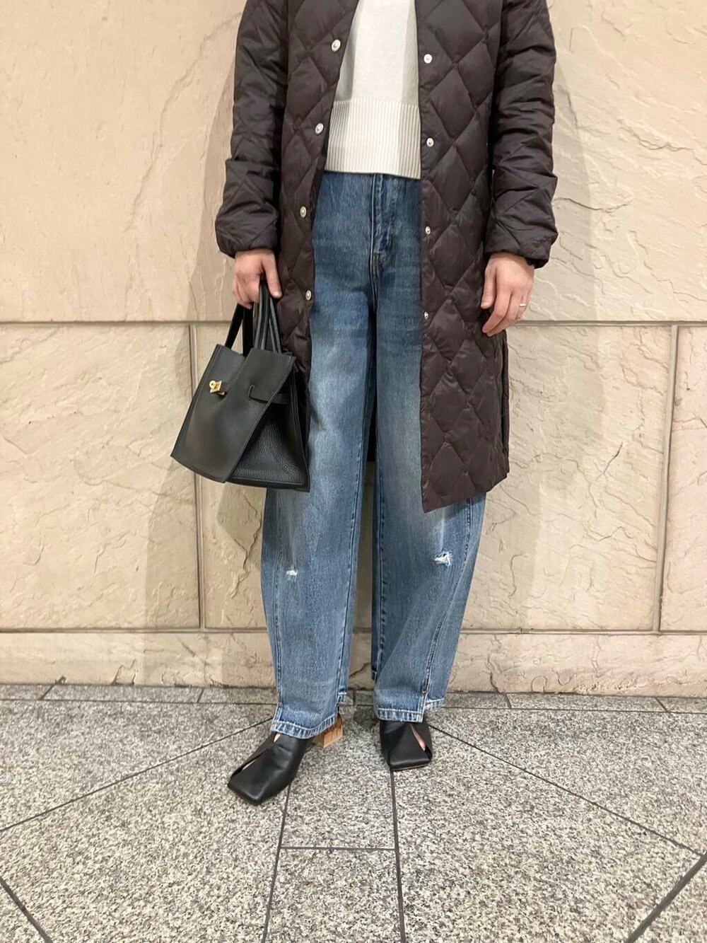 ブルー系のデニムパンツ、ホワイト系のニット/セーター、ブラック系のパンプスを着用したレディースの秋コーディネートの6枚目の写真