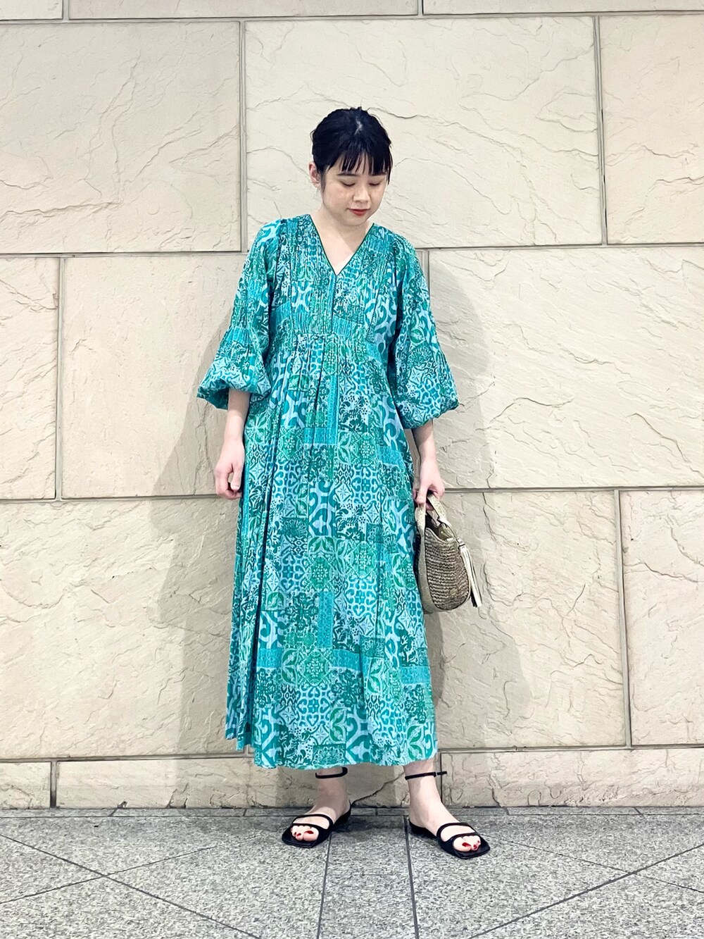 グリーン系のワンピース/ドレス、ブラウン系のかごバッグを着用したレディースの春コーディネートの2枚目の写真