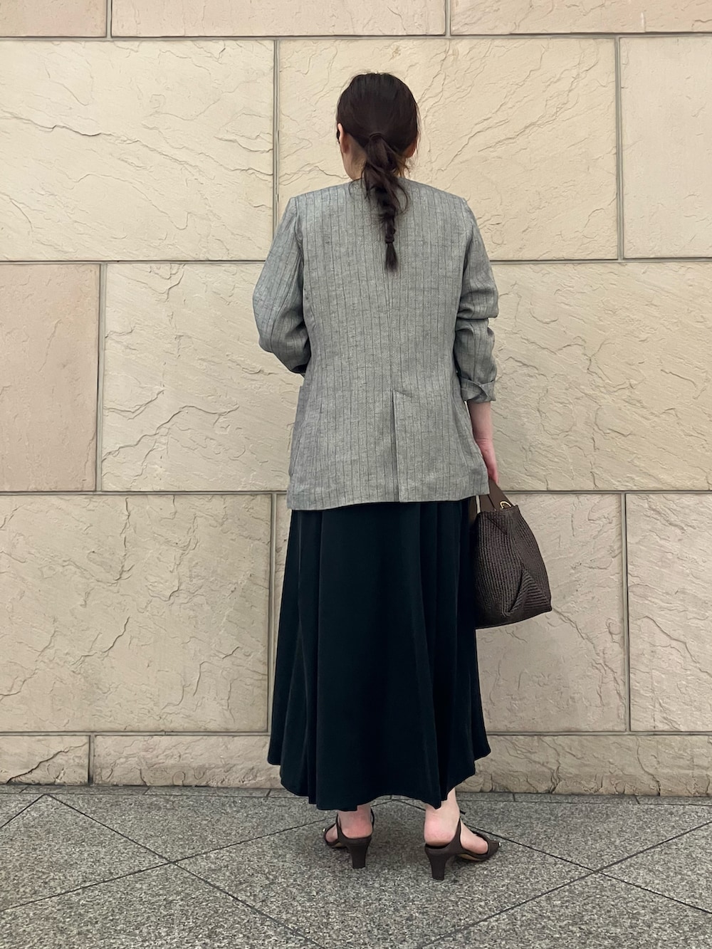 ブラウン系のタンクトップ、グレー系のノーカラージャケット、ブラック系のワンピースを着用したレディースの春コーディネートの3枚目の写真