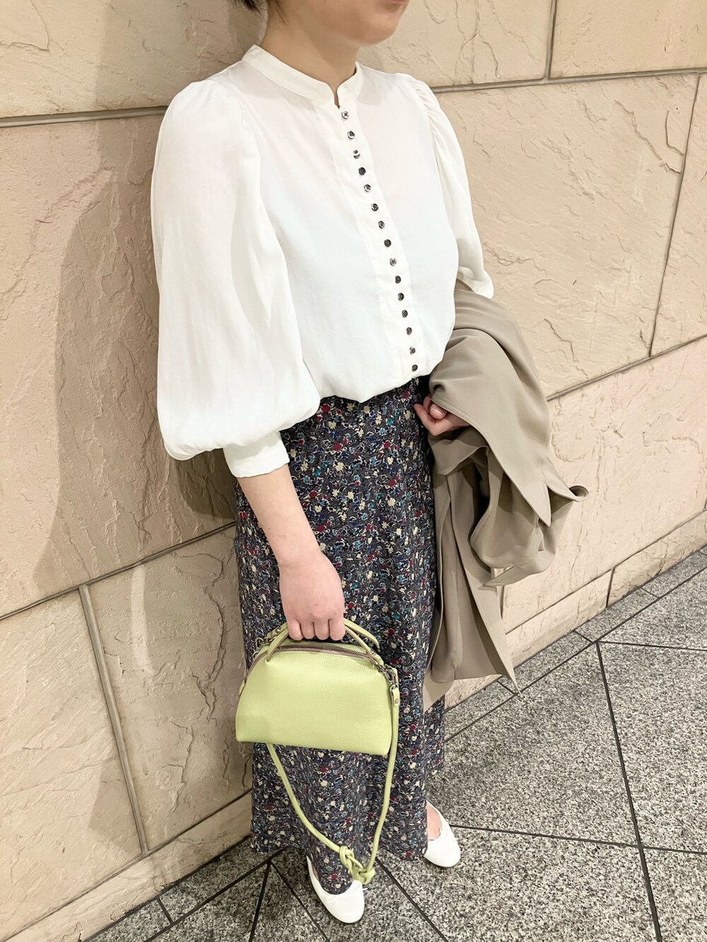 ベージュ系のトレンチコート、ブラック系のスカート、ホワイト系のシャツ/ブラウスを着用したレディースの春コーディネートの5枚目の写真