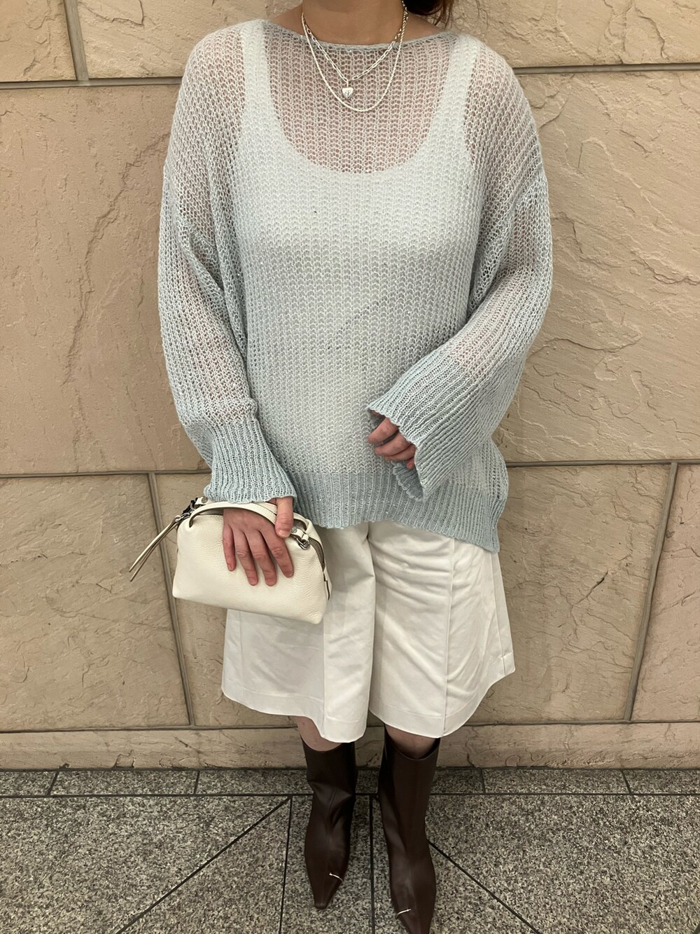 グリーン系のニット/セーター、ホワイト系のその他パンツ、ベージュ系のショルダーバッグを着用したレディースの秋コーディネートの4枚目の写真